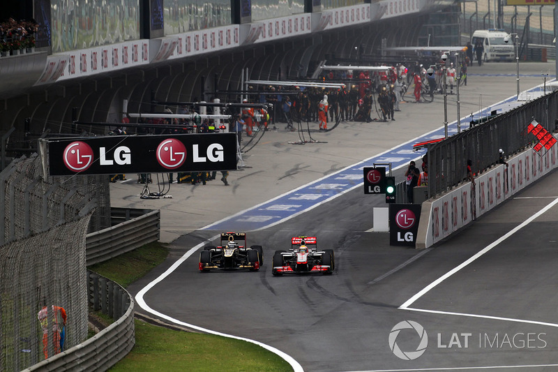 Kimi Raikkonen, Lotus E20 y Lewis Hamilton, McLaren MP4-27 batalla en pit lane