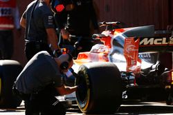 A Pirelli engineer checks a tyre on the Fernando Alonso McLaren MCL32