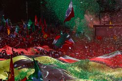 Confetti falls around the huge crowd of Ferrari fans gathered for the podium ceremony