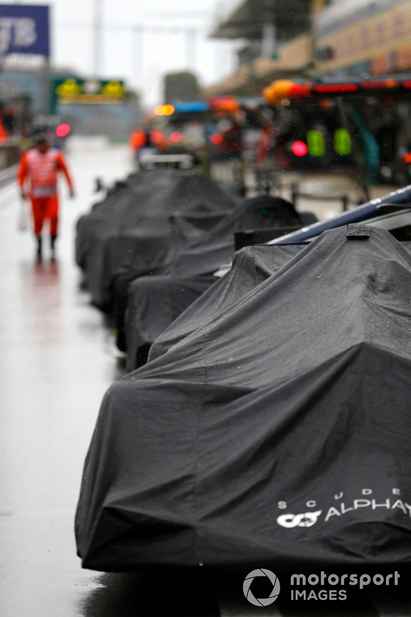 Coches cubiertos por la lluvia en el pit lane
