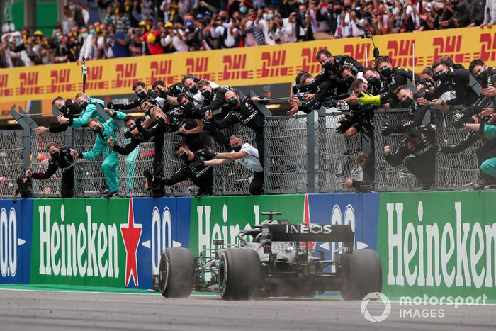 Lewis Hamilton, Mercedes F1 W11, 1ª posición, cruza la línea para el deleite de su equipo en el pit wall