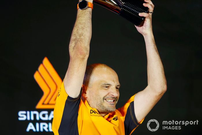 El delegado de McLaren levanta el trofeo en señal de celebración 