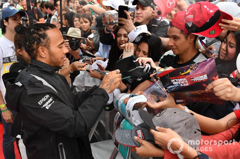 Lewis Hamilton, Mercedes AMG F1 signs an autograph for a fan 