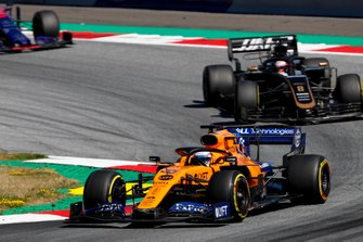 Carlos Sainz Jr., McLaren MCL34, leads Romain Grosjean, Haas F1 Team VF-19