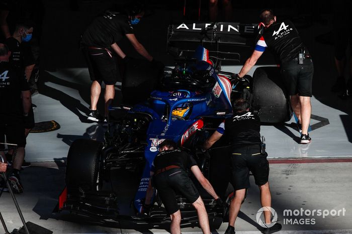 Los mecánicos empujan a Fernando Alonso, Alpine A521, de vuelta al garaje