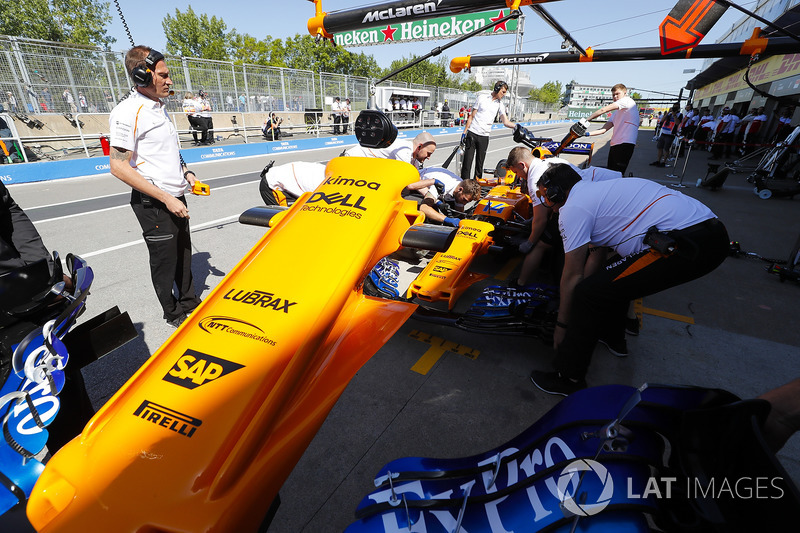 Les mécaniciens travaillent sur la voiture de Fernando Alonso McLaren MCL33 dans la voie des stands, et enlèvent le nez de la voiture