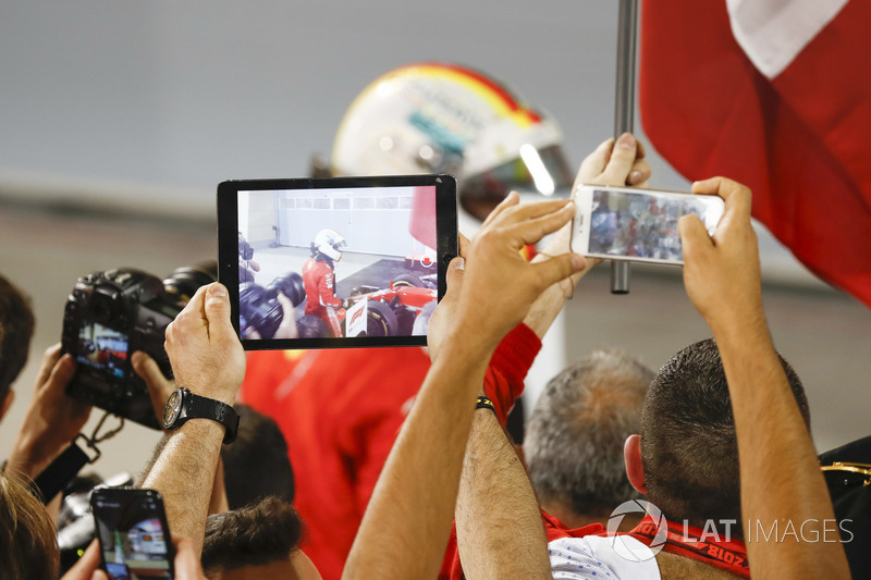 I membri del team fotografano l'arrivo di Sebastian Vettel, Ferrari, 1° classificato, nel parco chiuso