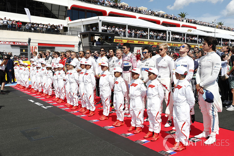 Drivers and Grid Kids lined up for the national anthem prior to the start of the race