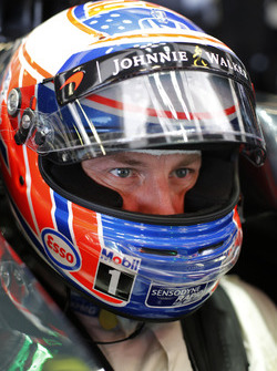 Jenson Button, McLaren MP4-31 sits with crash helmet on in the cockpit