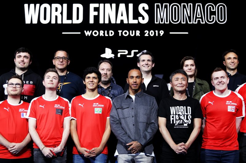 Formula 1 Driver, Lewis Hamilton and producer of Gran Turismo, Kazunori Yamauchi pose for a photo on stage with the competitors
