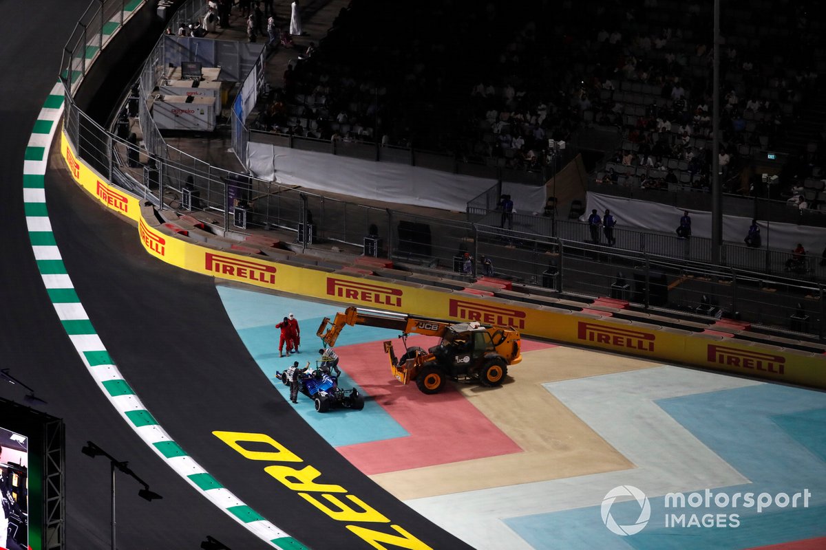 Los oficiales de pista retiran el coche dañado de George Russell, Williams FW43B