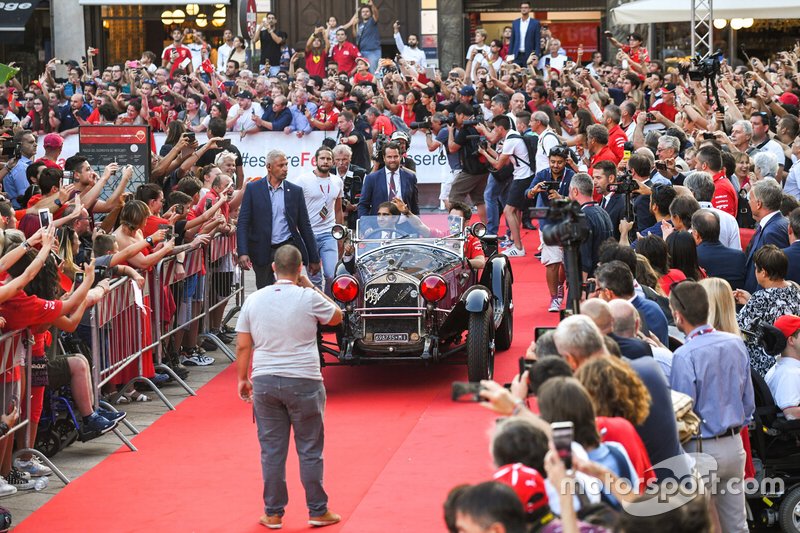 Charles Leclerc, Ferrari waves to the crowd from the passenger seat of a classic Alfa Romeo