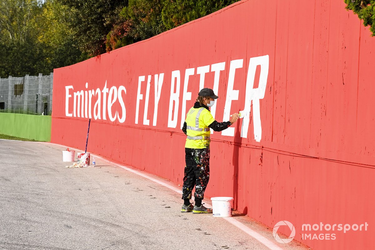Un ouvrier peint les sponsors sur les murs