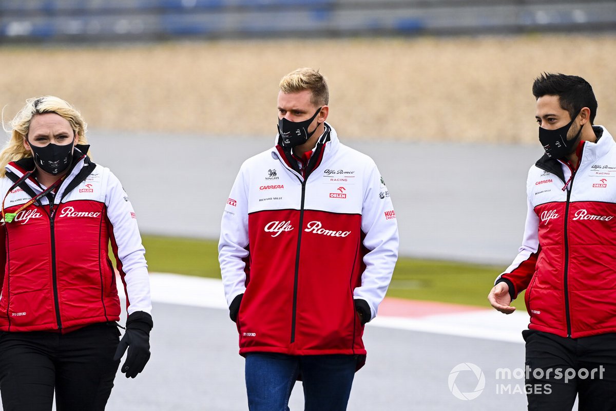 Mick Schumacher, Alfa Romeo, recorre la pista con miembros del equipo
