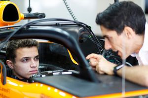 Lando Norris, McLaren, in cockpit, talks to a colleague