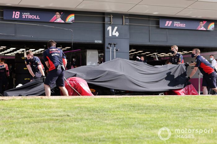 Los mecánicos de Red Bull con el monoplaza dañado de Alex Albon, Red Bull Racing RB16 en el garaje bajo una lona después de su accidente en la FP2