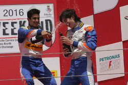 Kush Maini and Lorenzo Colombo celebrate with champagne on the podium