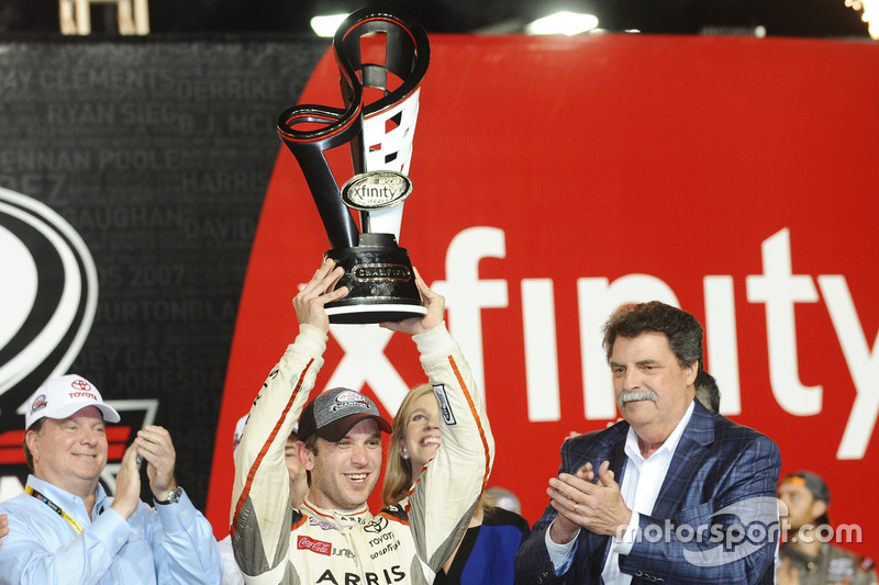 Ganador de la carrera y Campeón 2016 Daniel Suárez, Joe Gibbs Racing Toyota, NASCAR presidente Mike Helton con el trofeo del campeonato de Xfinity Series