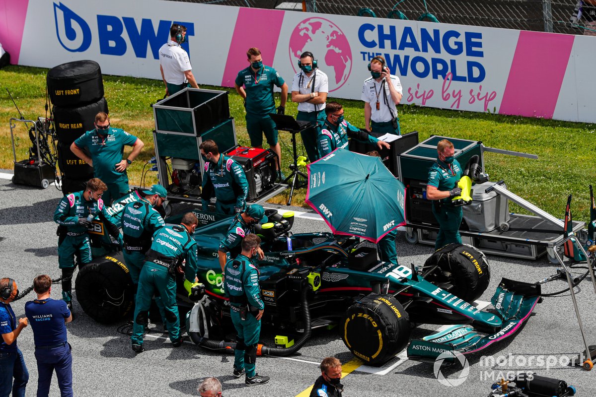 Los mecánicos preparan el coche de Lance Stroll, Aston Martin AMR21, en la parrilla de salida