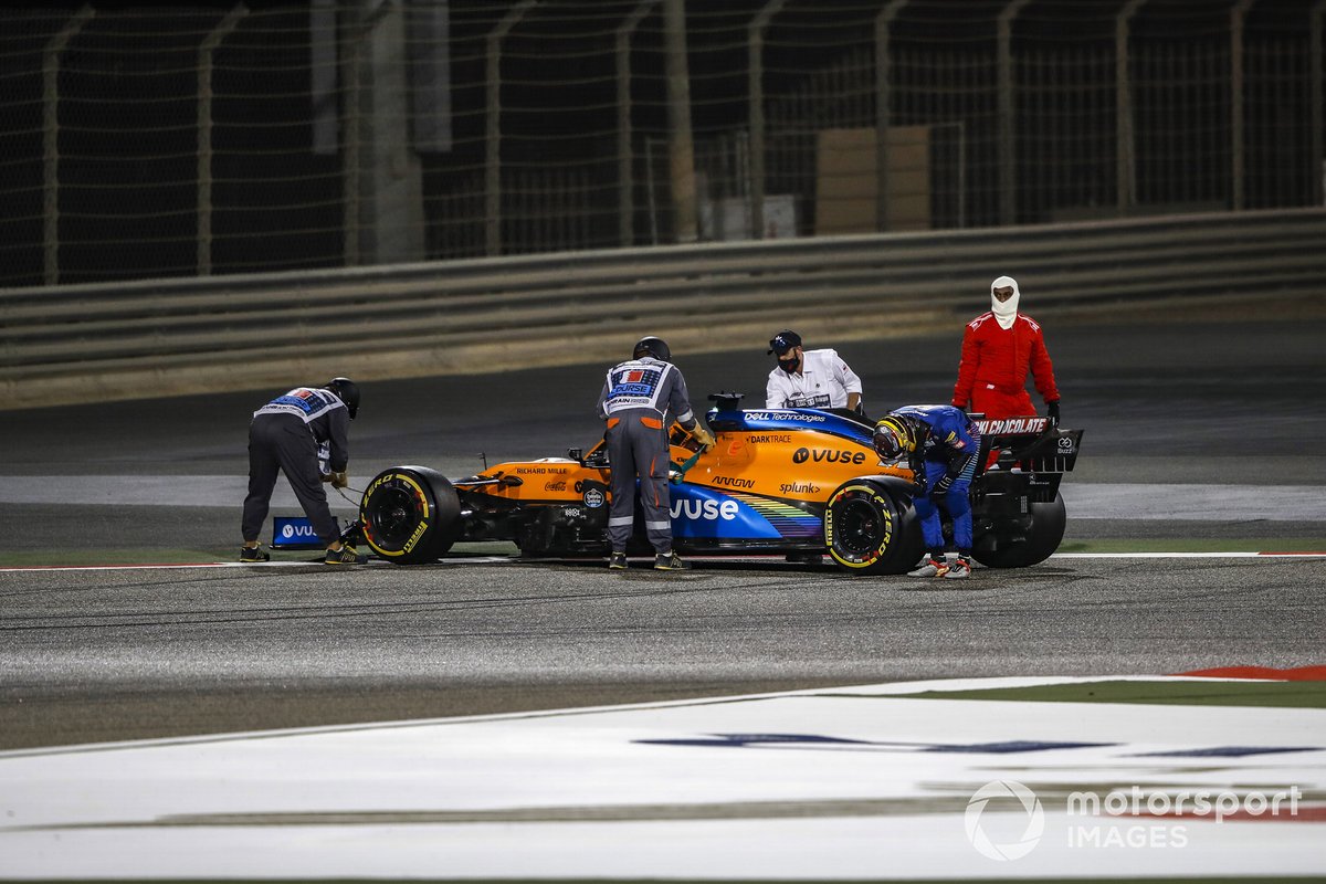 Carlos Sainz Jr., McLaren, mira la parte trasera de su coche mientras los oficiales trabajan para recuperarlo