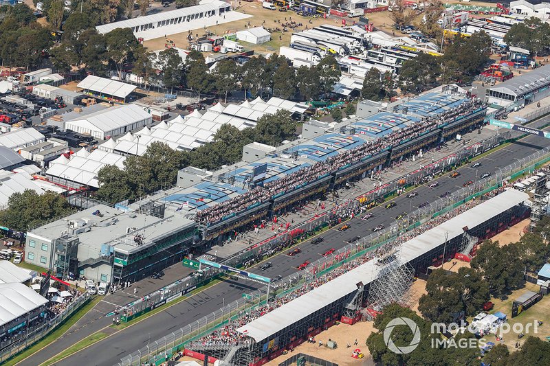 Mechanics clear the grid as the drivers pull away for the formation lap