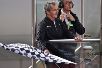 Alain Prost damalı bayrağı sallıyor
