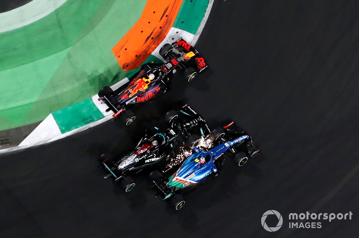 Max Verstappen, Red Bull Racing RB16B, Esteban Ocon, Alpine A521, and Lewis Hamilton, Mercedes W12, battle for the lead