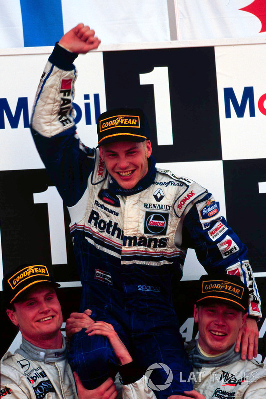 Jacques Villeneuve, Williams, est porté en triomphe par Mika Hakkinnen, McLaren et David Coulthard, McLaren