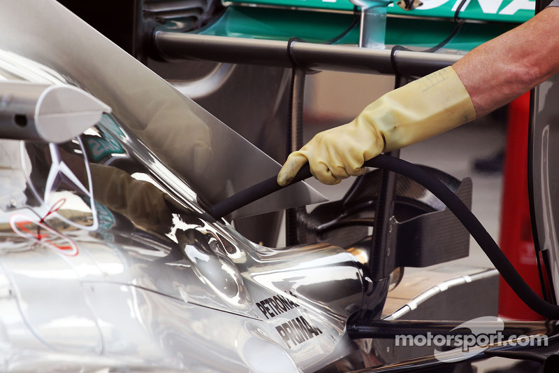 Mercedes AMG F1 W05 pipe attached to engine cover by a mechanic