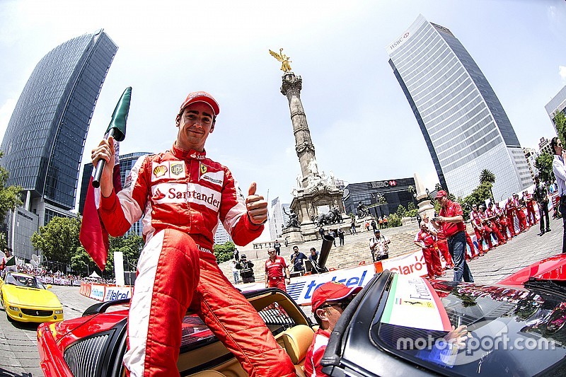 Esteban Gutiérrez con una bandera de México festeja en la columna del Angel de la Independencia durante Scuderia Ferrari Street Demo en la Ciudad de México