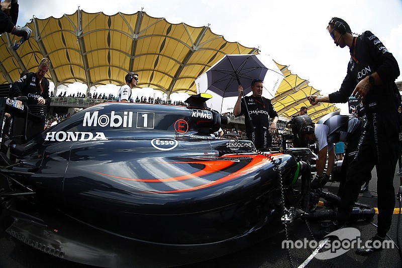 L'équipe au travail sur la voiture de Jenson Button, McLaren MP4-31, sur la grille