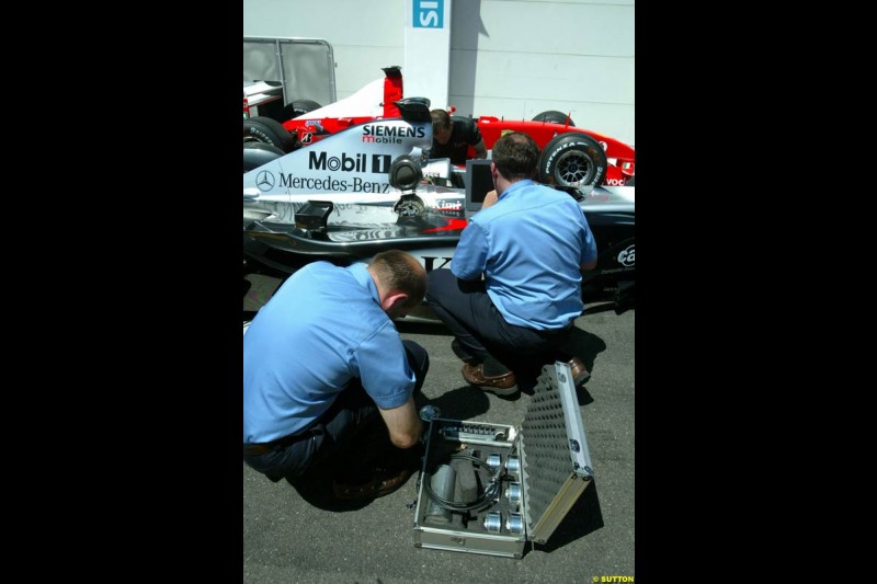 The FIA inspect Kimi Raikkonen's McLaren Mercedes MP4/17 in parc ferme post qualifying. French Grand Prix, Magny-Cours, France, 20 July 2002.
