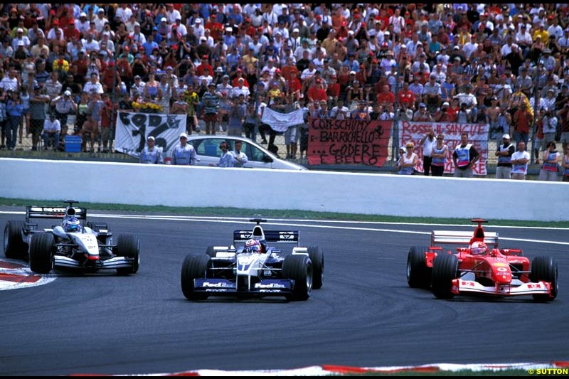 Juan Pablo Montoya, Williams BMW FW24, Michael Schumacher, Ferrari F2002 and Kimi Raikkonen, McLaren, fight for position. French Grand Prix, Magny Cours, France, July 21st 2002.