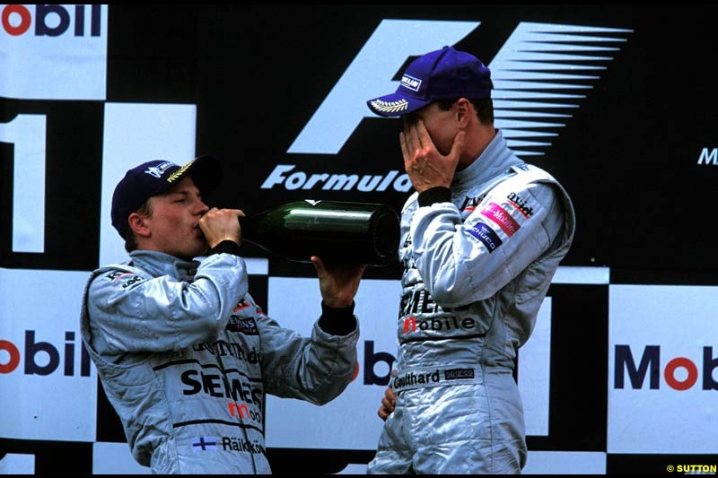 Kimi Raikkonen and David Coulthard, McLaren, celebrate second and third on the podium. French Grand Prix, Magny Cours, France, July 21st 2002.