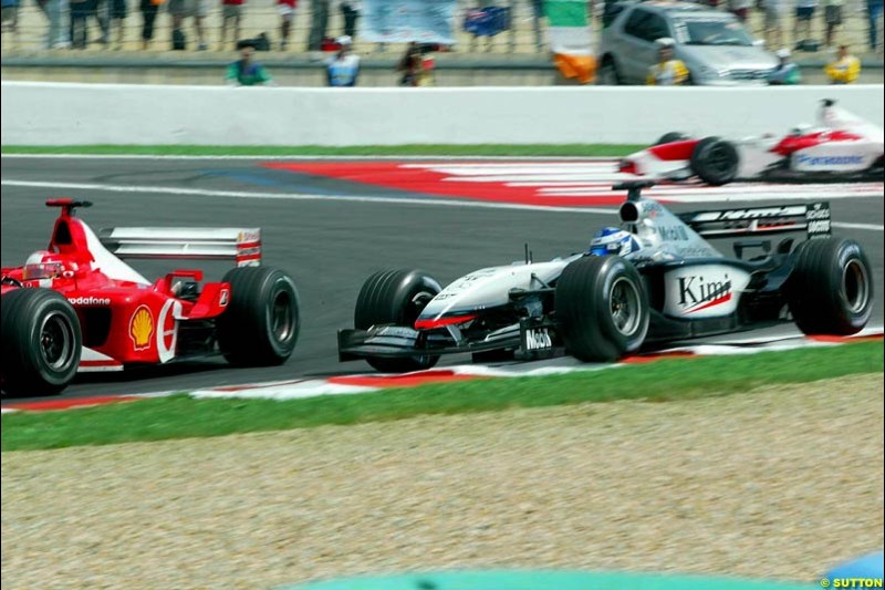 Michael Schumacher, Ferrari, passes Kimi Raikkonen, McLaren, for the lead of the French Grand Prix, Magny Cours, France, July 21st 2002.