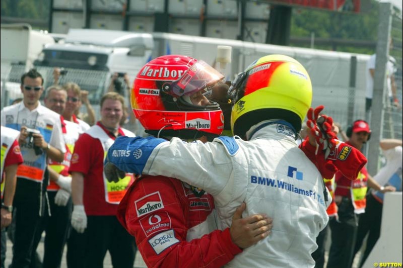 Michael Schumacher, Ferrari, and Ralf Schumacher, Williams, embrace after both qualify on the front row. German Grand Prix, Hockenheim, Germany, July 27th 2002.