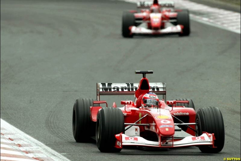 Rubens Barrichello, Ferrari, briefly leads team mate Michael Schumacher during pit stops. Belgian Grand Prix, Spa-Francorchamps, Belgium, September 1st 2002.