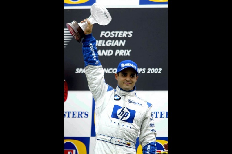 Juan Pablo Montoya, Williams, celebrates third on the podium. Belgian Grand Prix, Spa-Francorchamps, Belgium, September 1st 2002. 