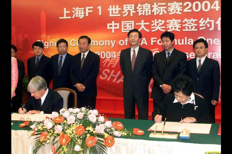 Formula One chief Bernie Ecclestone and Juan Wei, Deputy Manager of the Shanghai International Circuit Co Ltd, sign documents at a ceremony in Shanghai, China, October 21, 2002. Ecclestone signed an agreement to help the city host F1 Grand Prix races from 2004 to 2010.