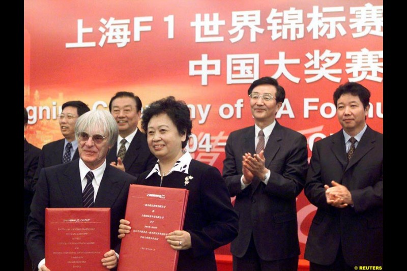 Formula One chief Bernie Ecclestone and Juan Wei, Deputy Manager of the Shanghai International Circuit Co Ltd, sign documents at a ceremony in Shanghai, China, October 21, 2002. Ecclestone signed an agreement to help the city host F1 Grand Prix races from 2004 to 2010.