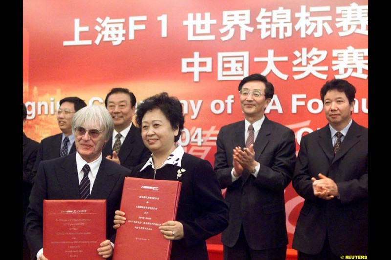 Formula One chief Bernie Ecclestone and Juan Wei, Deputy Manager of the Shanghai International Circuit Co Ltd, sign documents at a ceremony in Shanghai, China, October 21, 2002. Ecclestone signed an agreement to help the city host F1 Grand Prix races from 2004 to 2010. 