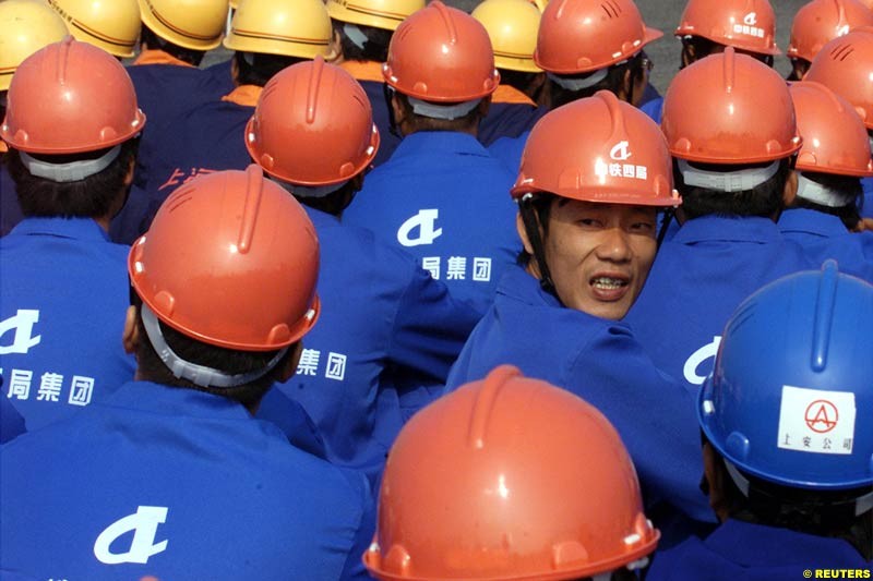 Chinese workers watch the Shanghai Circuit ground-breaking ceremony October 17, 2002. Shanghai has begun work on a 5.45-km (3.39-mile) racetrack north of the city, and hoping to host a Formula One Grand Prix event in 2004. 