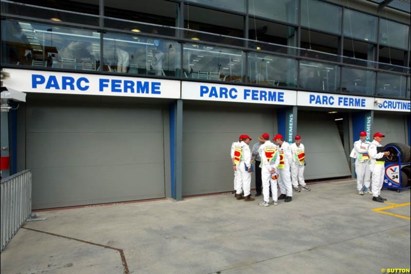 Scrutineers lock up Parc Ferme for the night. Saturday, Australian GP, March 8th 2003.