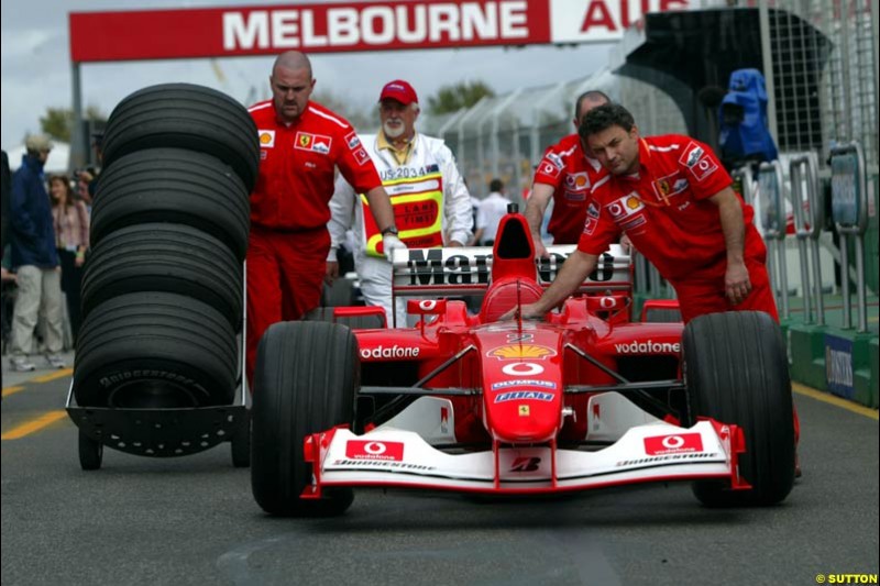 The Ferrari crew bring back the car to the garage under the supervision of the scrutineer after qualifying for the Australian GP. Melbourne, March 8th 2003.
