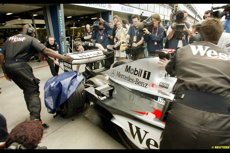 David Coulthard's McLaren is wheeled back into the team garage after he blew a tyre during Saturday practice for the Australian GP. Melbourne, March 8th 2003.