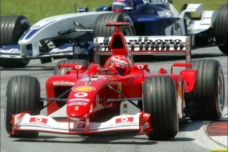 Michael Schumacher, Ferrari, followed by Juan Pablo Montoya, Williams, during Friday practice session at Sepang International Circuit. Malaysian GP, March 21st 2003.