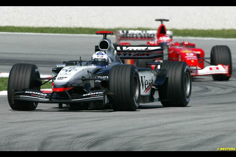 David Coulthard, McLaren, followed by Rubens Barrichello, Ferrari, during Saturday practice for the Malaysian GP. Sepang, March 22nd 2003.