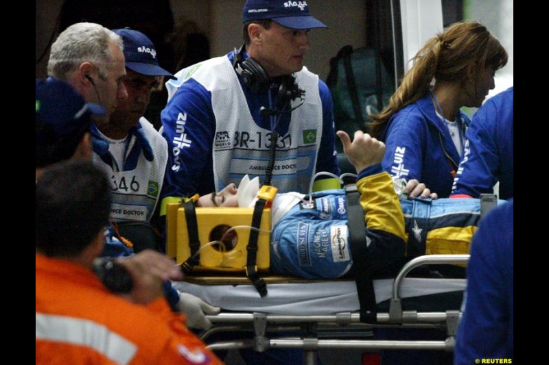 Fernando Alonso, Renault, gives a thumbs up after suffering a heavy accident that caused the race to be halted. Brazilian Grand Prix. Interlagos, Sao Paulo, April 6th 2003.