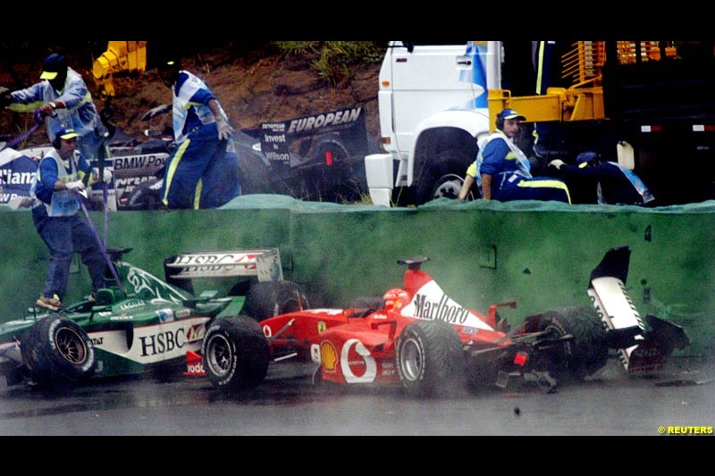 Wet conditions catch out Michael Schumacher, Ferrari, who joined a collection of cars that had fallen foul of turn 3. Brazilian Grand Prix. Interlagos, Sao Paulo, April 6th 2003.