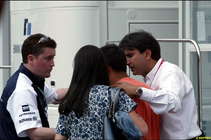 A Williams team Member, Connie Montoya and Pasquale from the FIA help calm down Juan Pablo Montoya after he was hit on the head by a TV camera in a media scrum at the Imola circuit, Italy. 17th April, 2003.